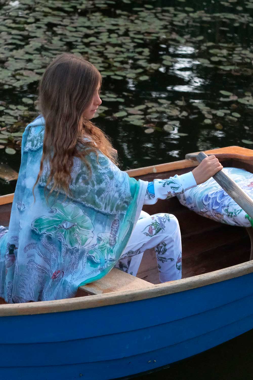 A young girl steering a rowing boat