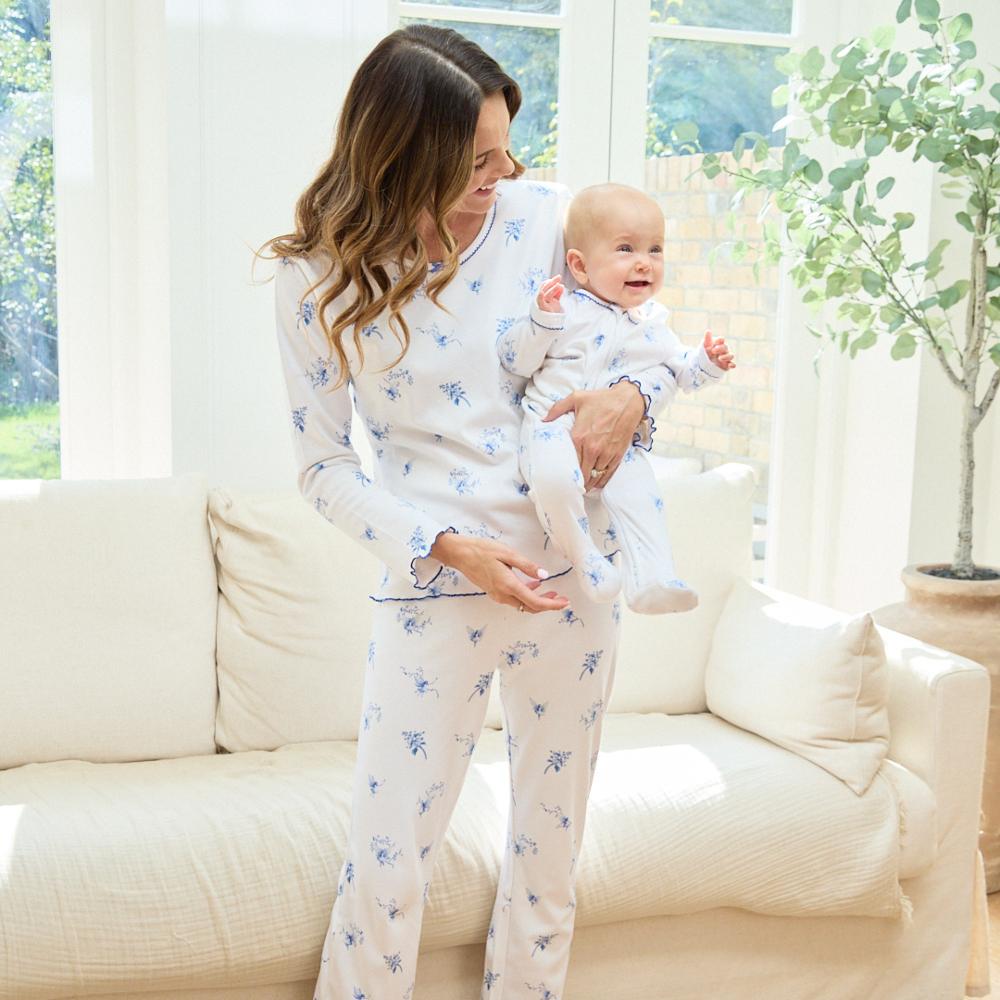 A mother holding a baby wearing matching pyjamas