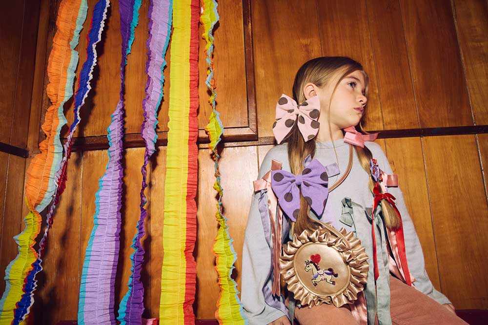 A young girl wearing brightly coloured accessories