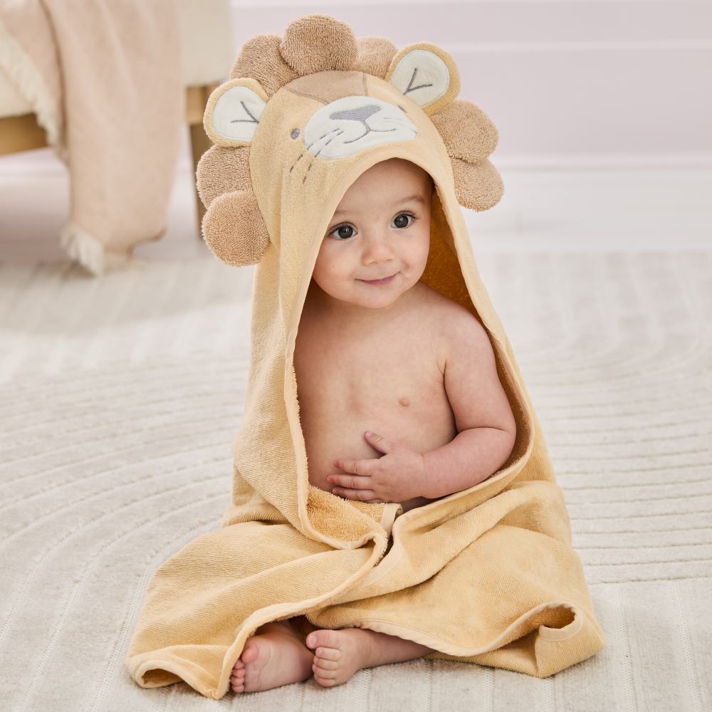 A baby sat on the floor wearing a hooded towel by Jojo Maman Bebe 