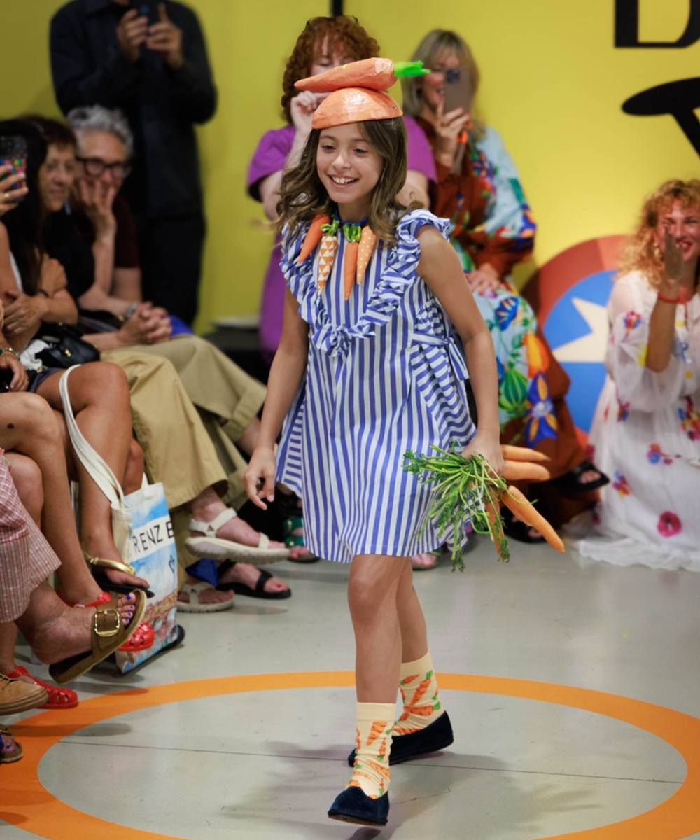 A girl walking down a catwalk for the Pirouette fashion show at Pitti Bimbo