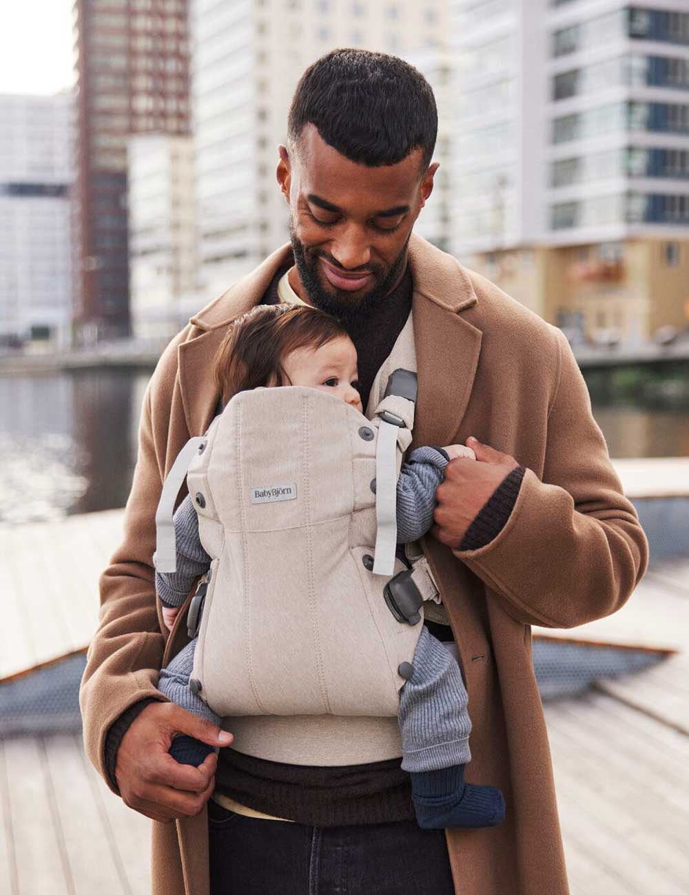 A man carrying a baby in a baby carrier