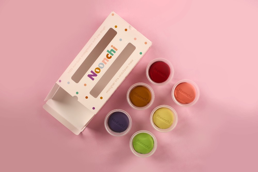 Tubs of Noonchi play dough displayed by its packaging