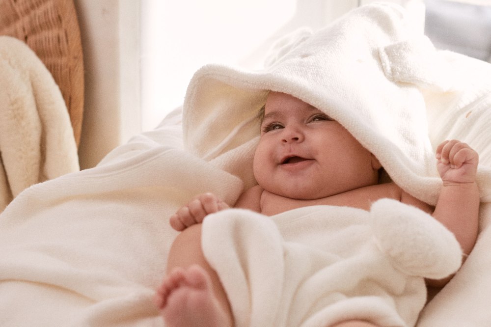 A baby lying in a rabbit ear bath towel