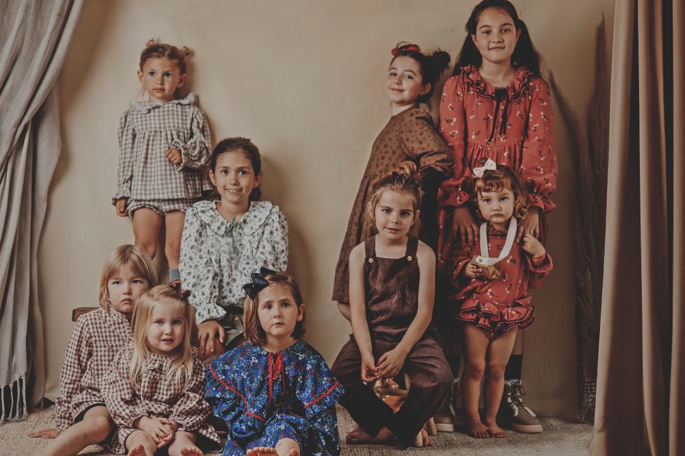 A group of children stood beside curtains