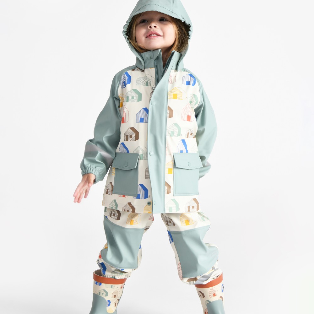 A young girl stood in a matching rainwear set and wellies 