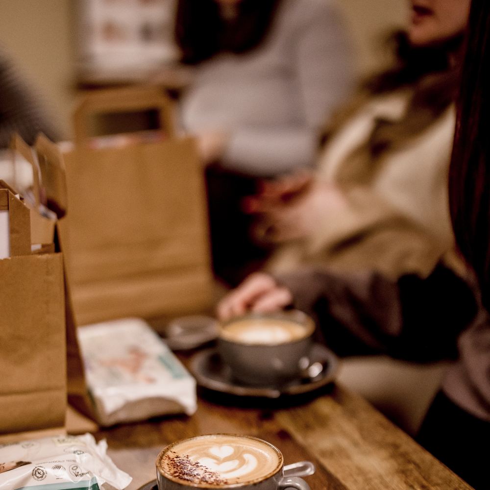 People sat at a table drinking coffee in the Eleanor Charles store 