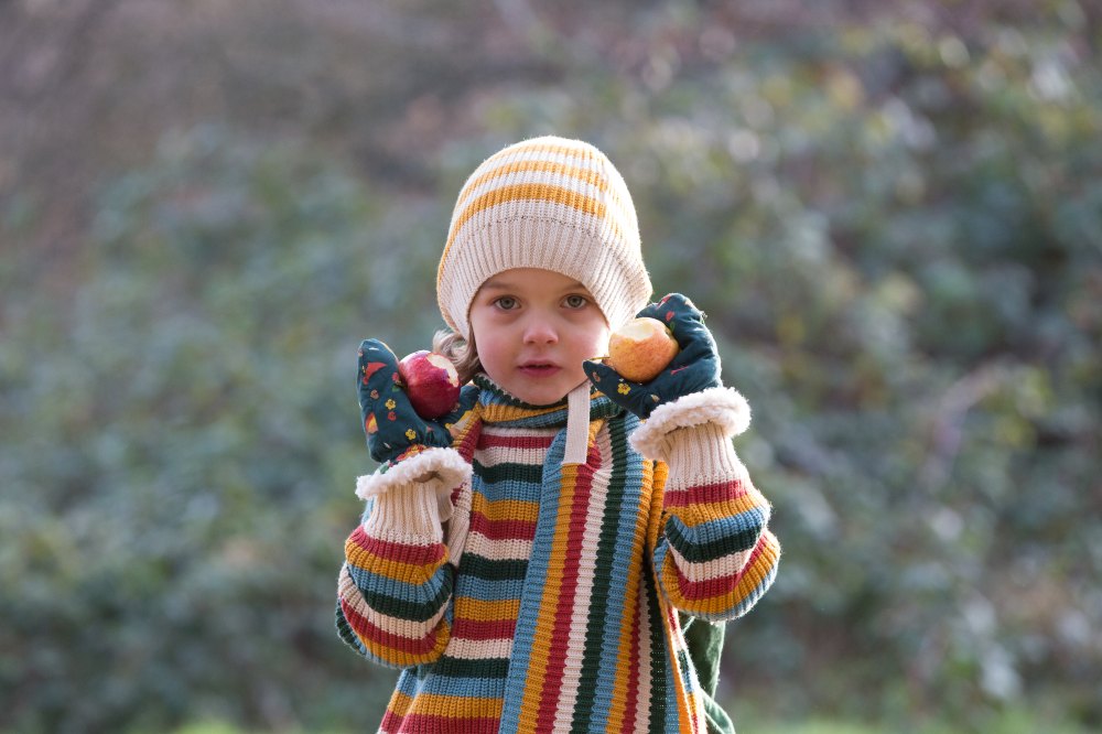 A girl outside wearing a striped jumper, scarf and hat by Little Green Radicals 