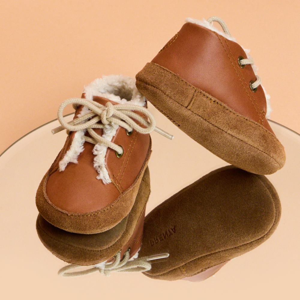 A pair of children's tan leather boots with white laces by PRENTA