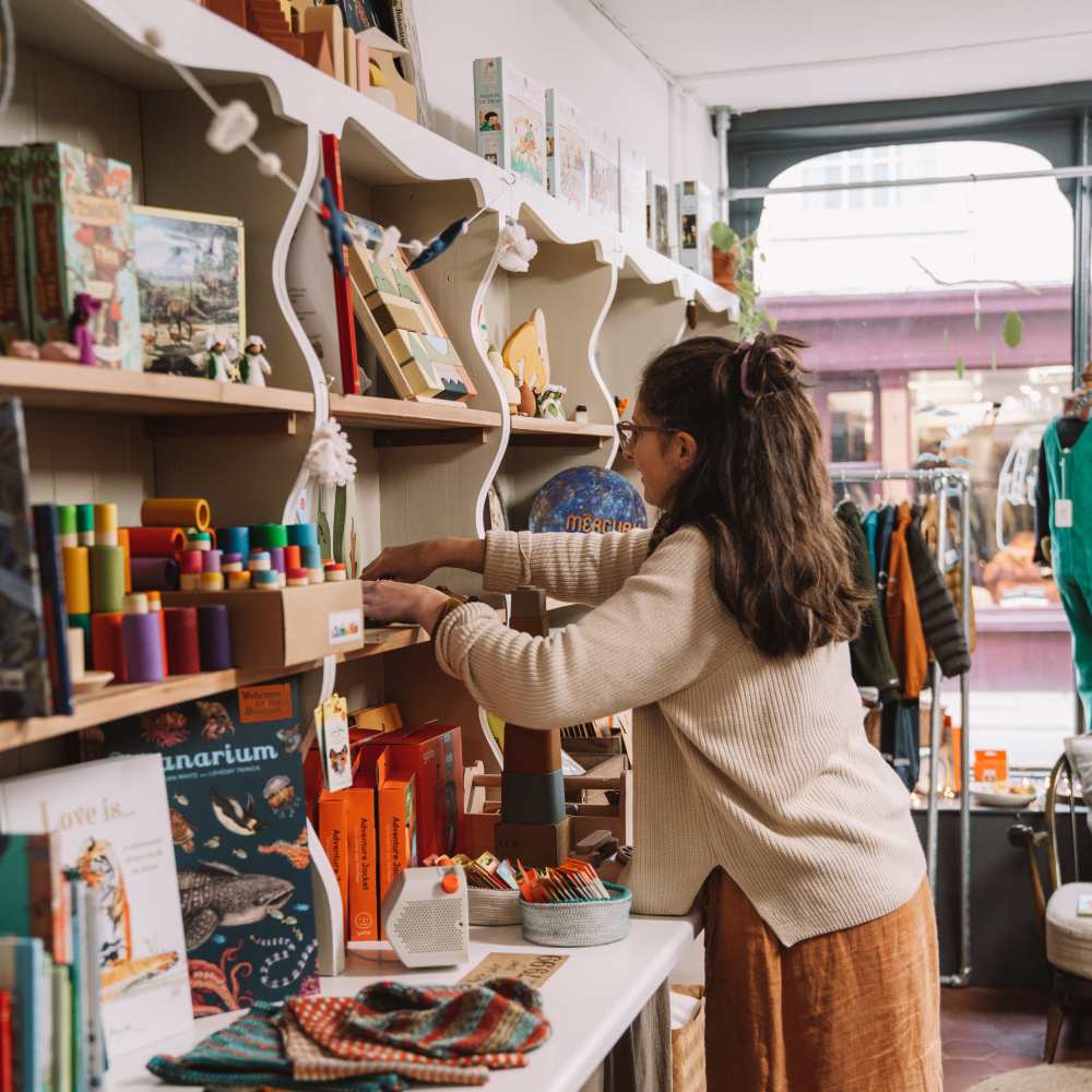 A woman arranging a display in the SMALL-FOLK store 