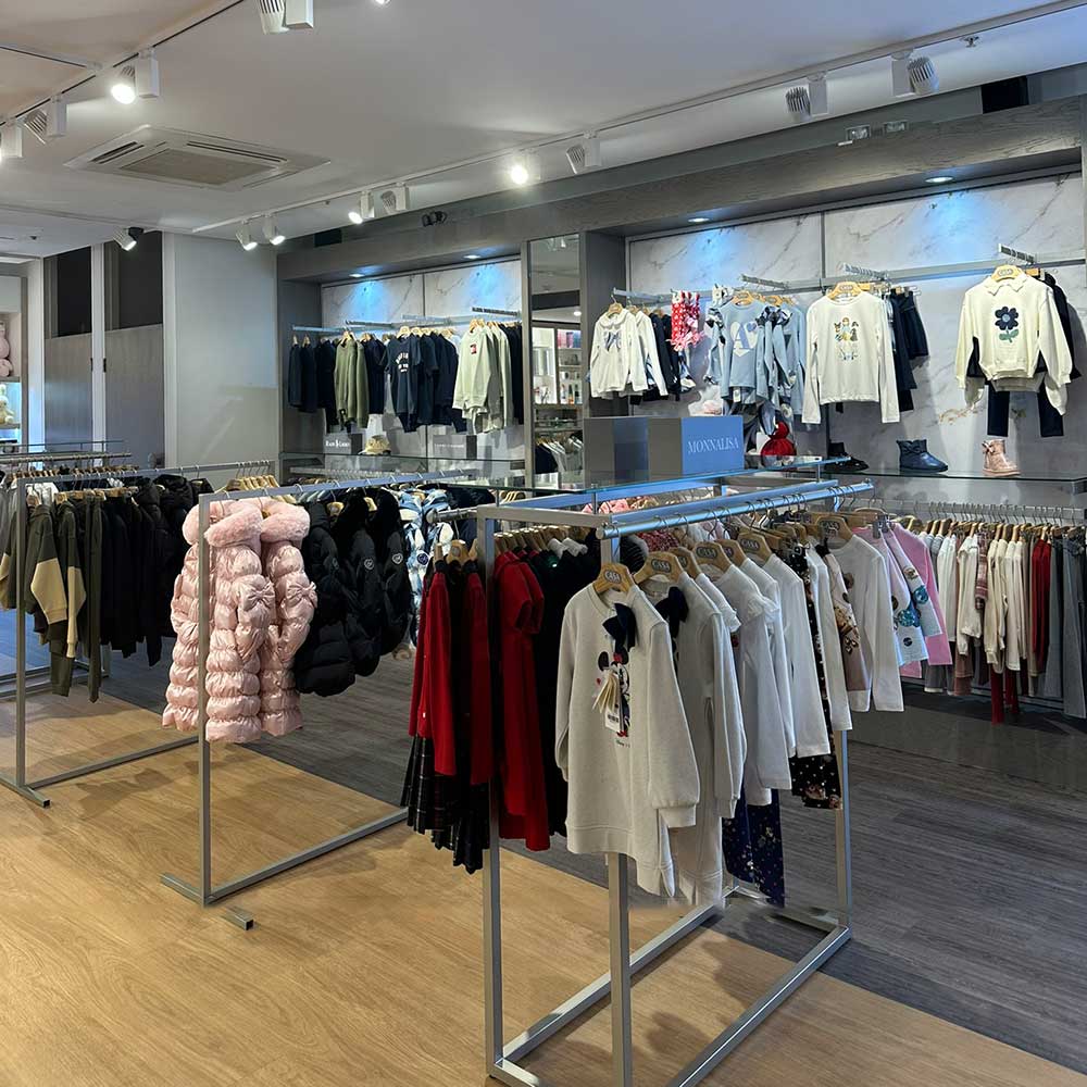Childrens clothing hanging on rails inside Casa Childrenswear store