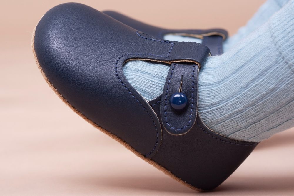 A dark blue pair of Early Days baby shoes
