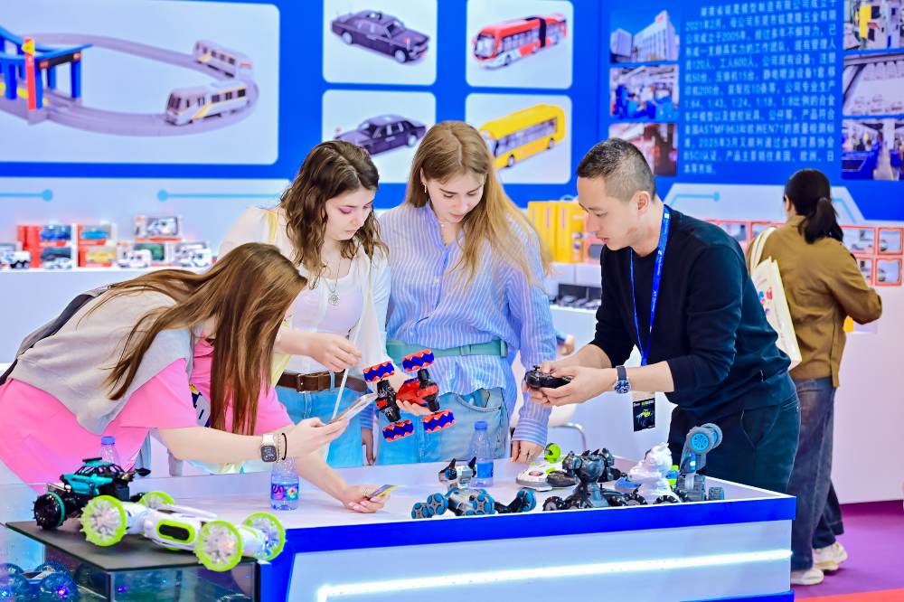 People stood on an exhibition stand looking at toys 