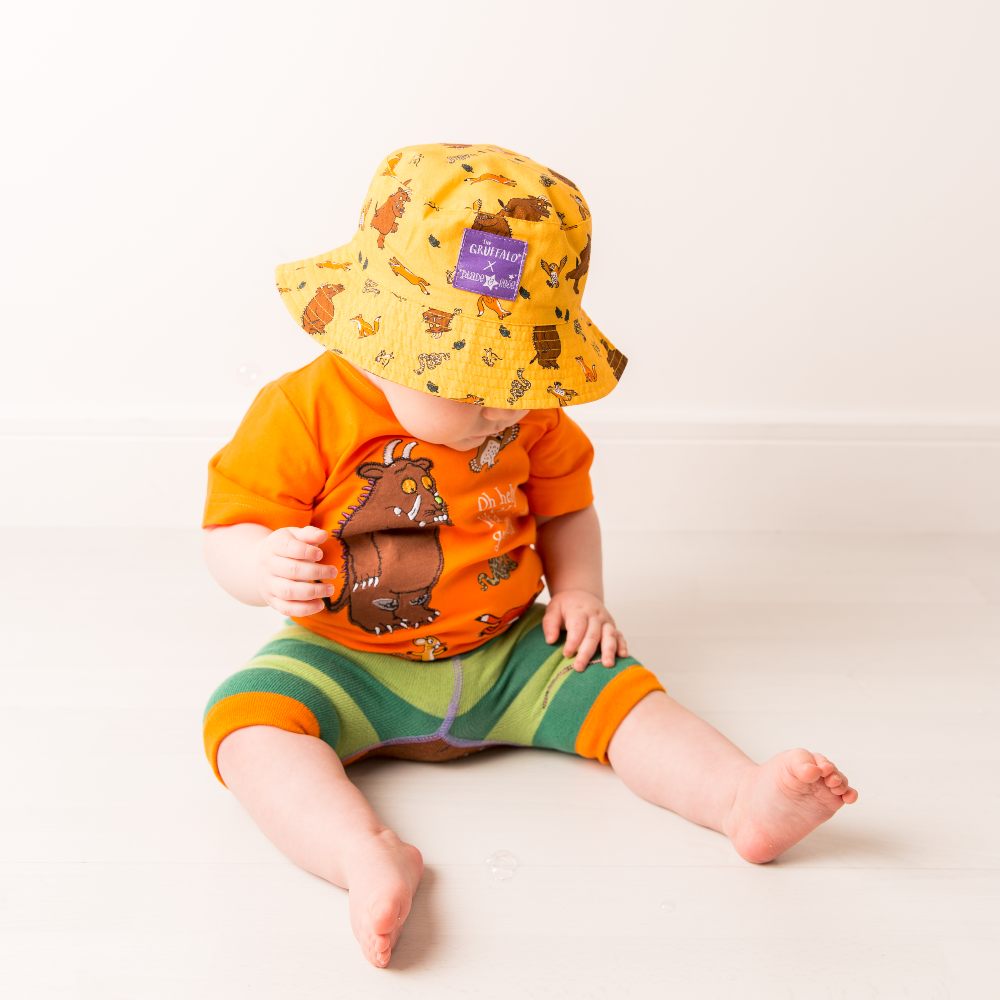 A baby sat on the floor wearing a summer outfit and hat from the Blade & Rose Gruffalo Collection 