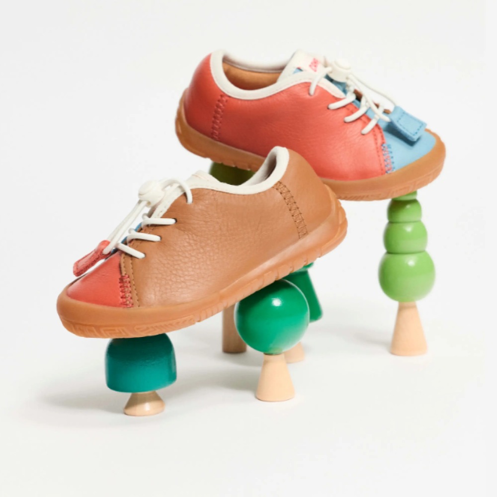 A pair of children's shoes displayed on wooden toy trees 