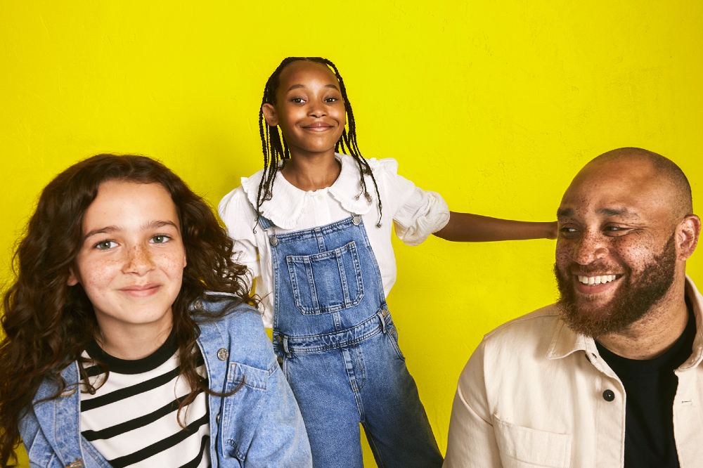 Two young girls smiling against a yellow background to promote the M&S x YoungMinds partnership