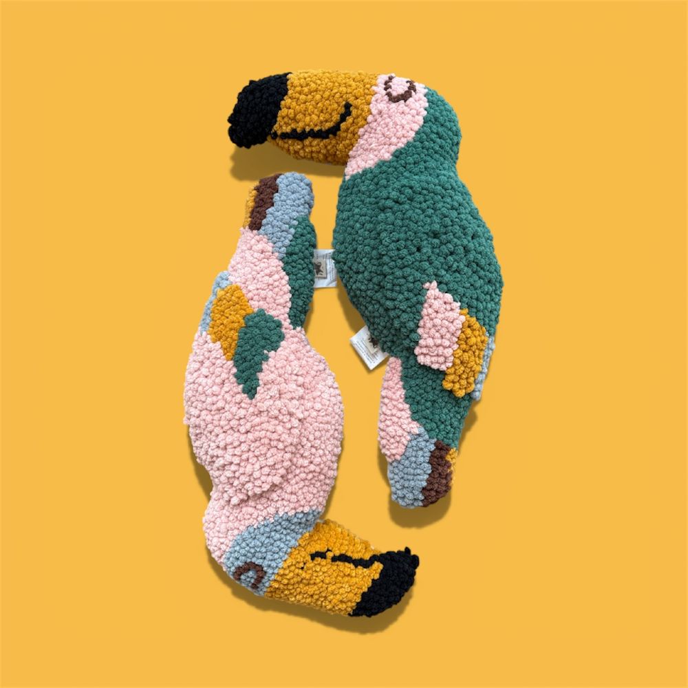 Two bird soft toys displayed on a yellow background 