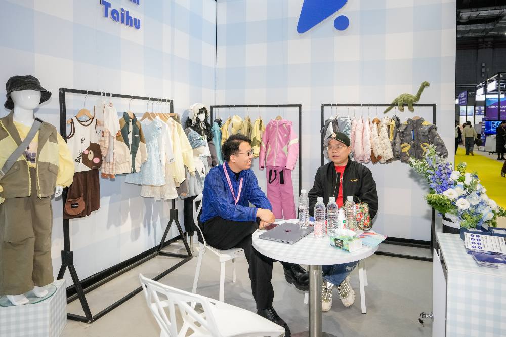 People sat on a childrenswear stand at the CHIC Kidz trade show 