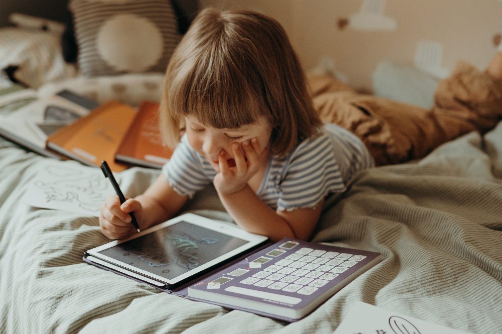 A child lying on a bed playing with a toy by Kidywolf