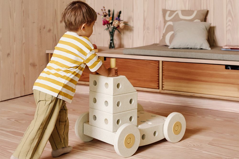 A child pushing a baby walker made from MODU building blocks