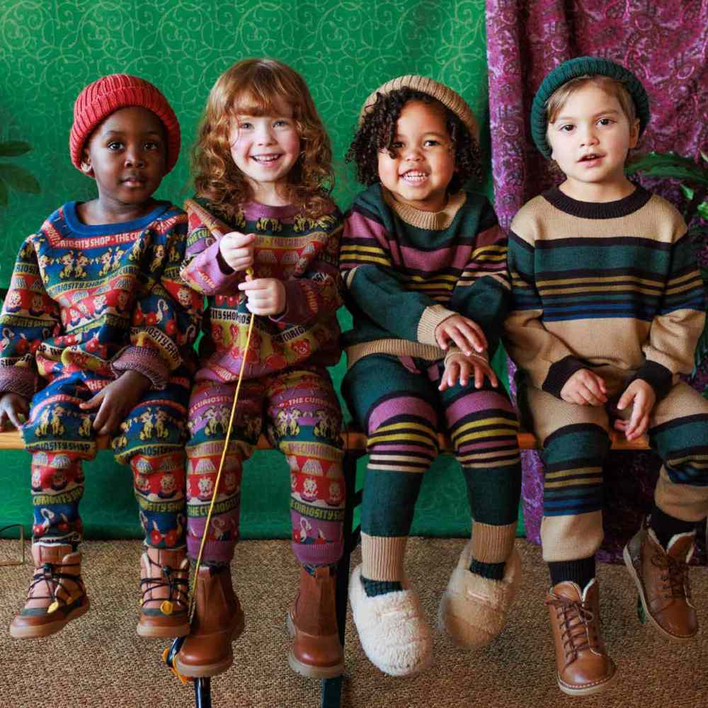 A row of children sat down wearing knitwear outfits 