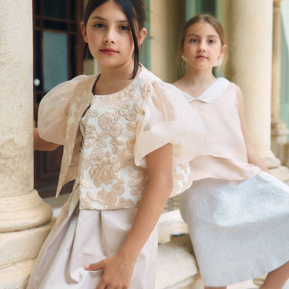 Two girls outside a building wearing special ocassionwear outfits 