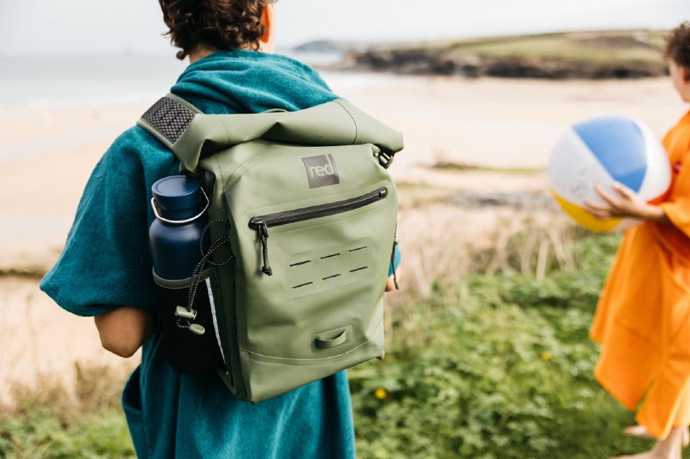 A child stood on a cliff wearing an olive green Adventure Waterproof Backpack by Red Equipment 