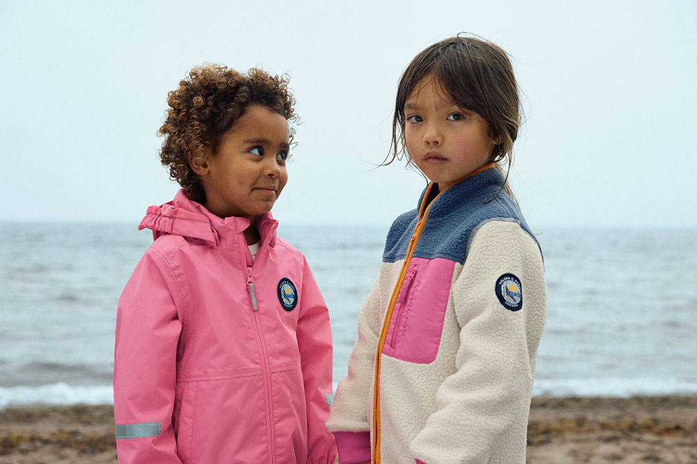 Two girls stood next to each other on the beach