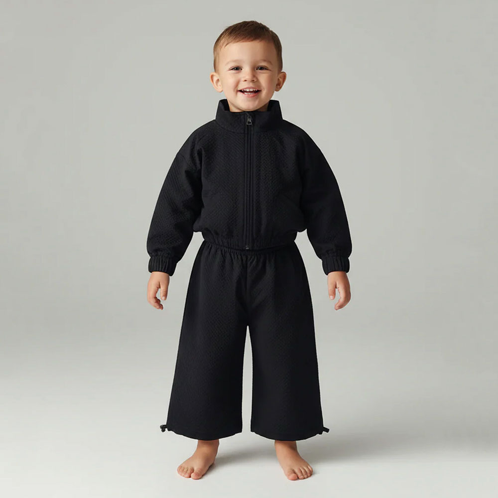 A child in a black top and trousers