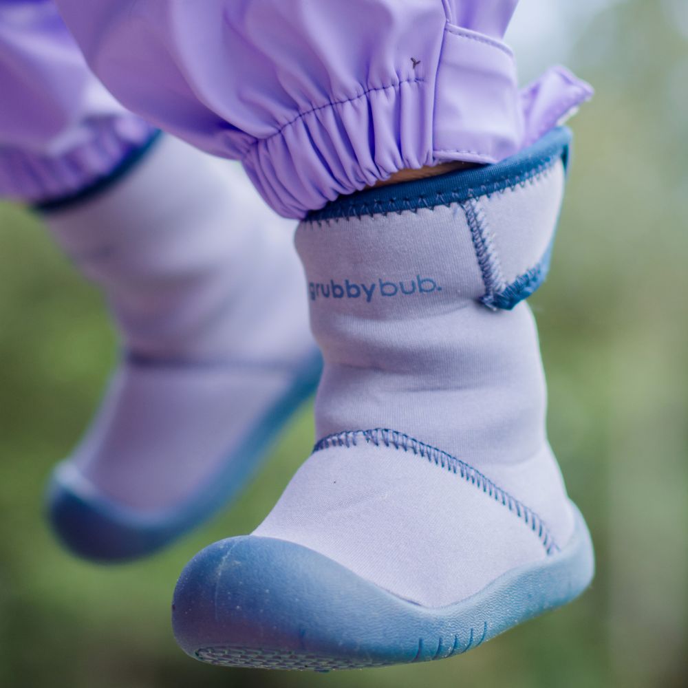 A close up of a baby's lilac and blue outdoor boot 