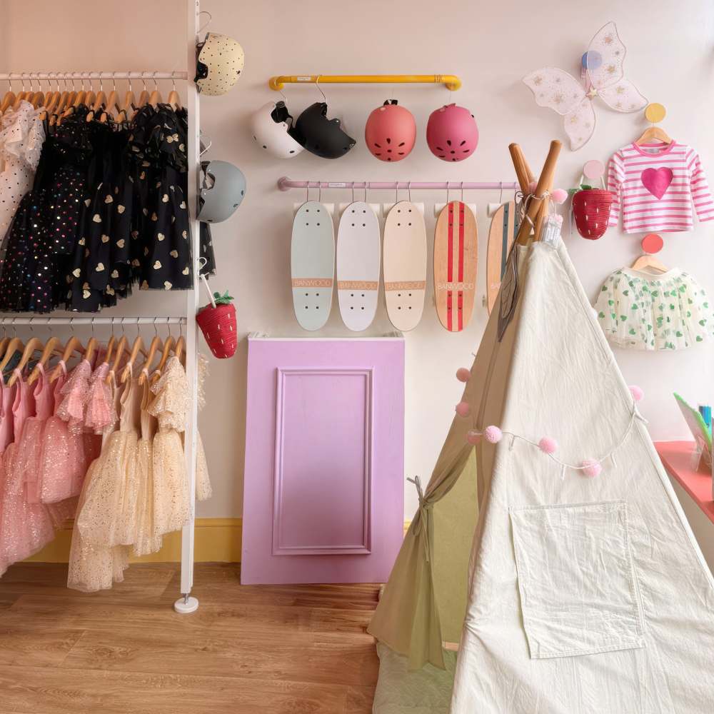 Children's clothes and accessories displayed in a shop beside a teepee