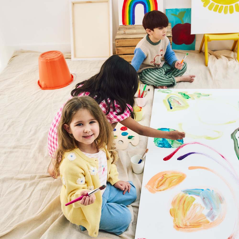 Children sat on the floor painting 