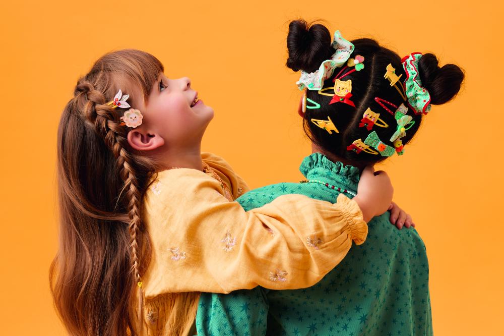 Two children shown wearing hair accessories from Djeco's new Plume collection