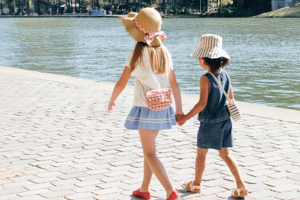 Two girls walking beside water wearing accessories by Rockahula kids