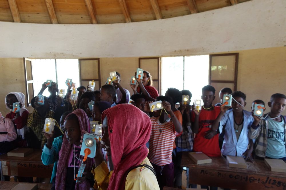 A group of children holding up DIY flash lights by Ambessa Play 