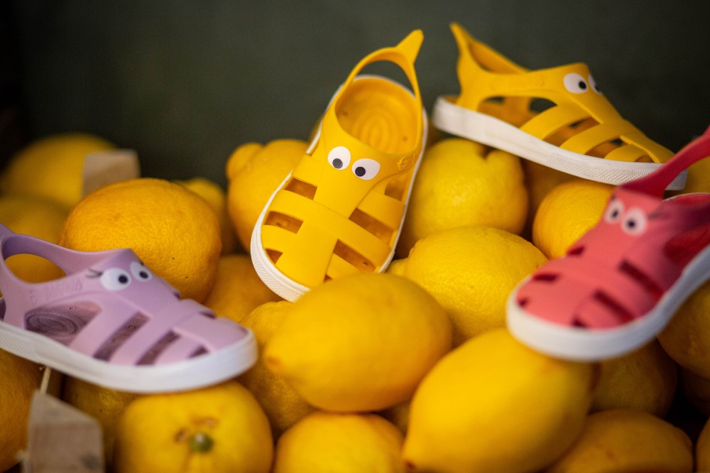Children's summer sandals with eyes on the front by Boatilus displayed on a box of lemons