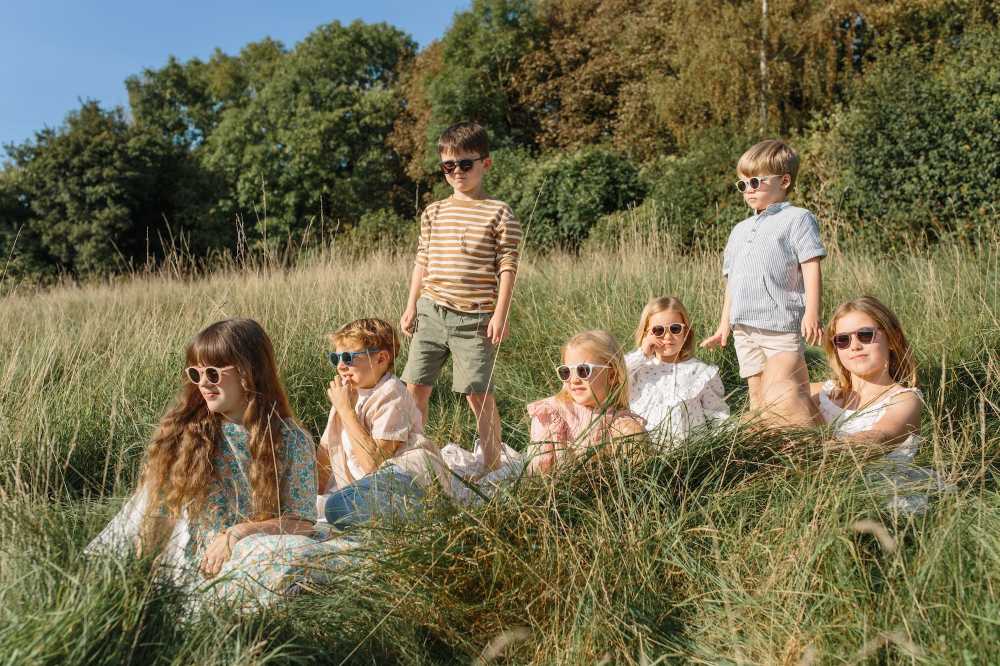 A group of children in a field wearing sunglasses by Leosun
