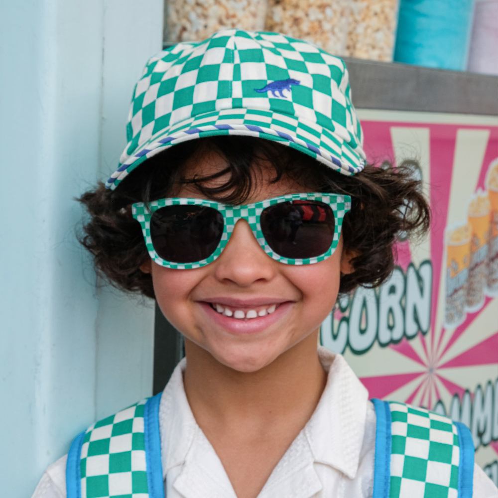 A child wearing a blue and white checked cap and matching rucksack from Rockahula Kids' Carnival Collection 