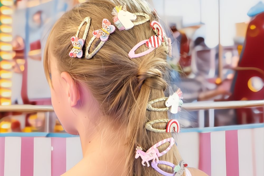 The back of a child's head shown with different hair clips from the Rockahula Kids Carnival Collection
