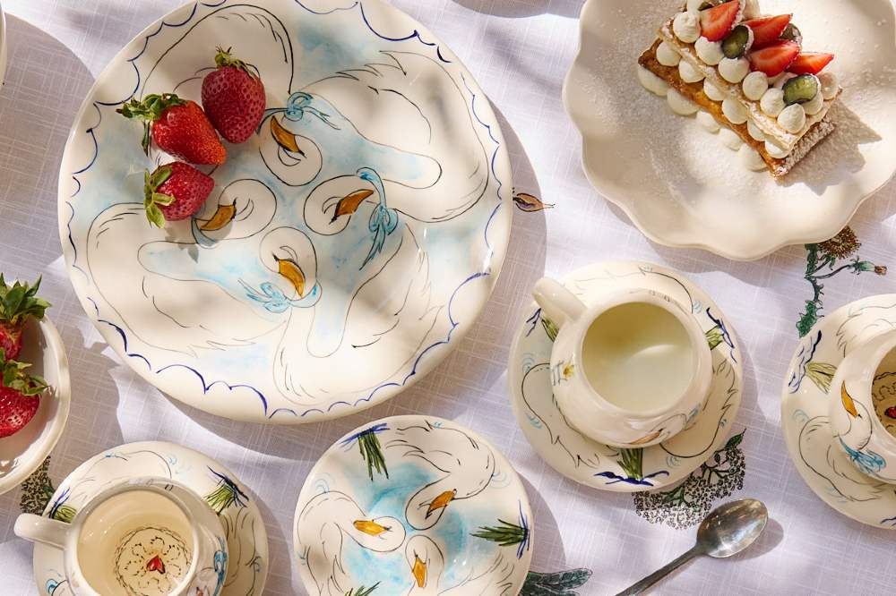 A table displaying a children's tableware set by Forivor and Villa Bologna Pottery