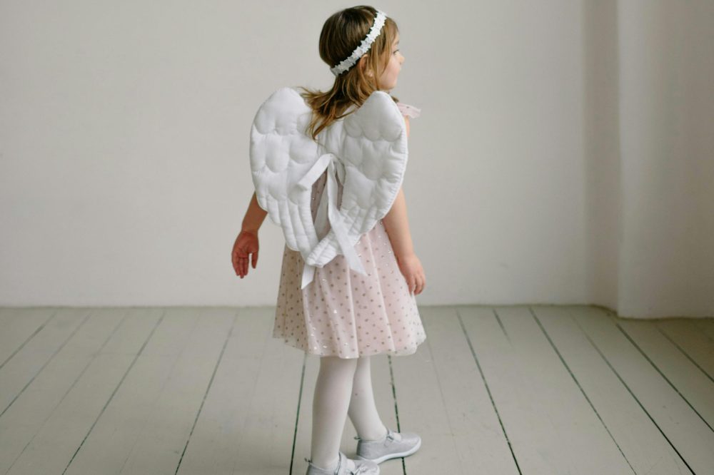 A girl in a white outfit with fairly wings and a crown