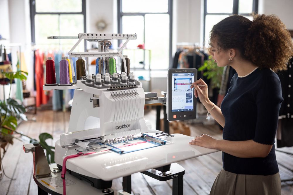 A woman stood operating a Brother embroidery machine