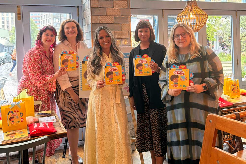 Amanda Jenner, stood next to four mothers holding a copy of her new book, Ready for My Potty