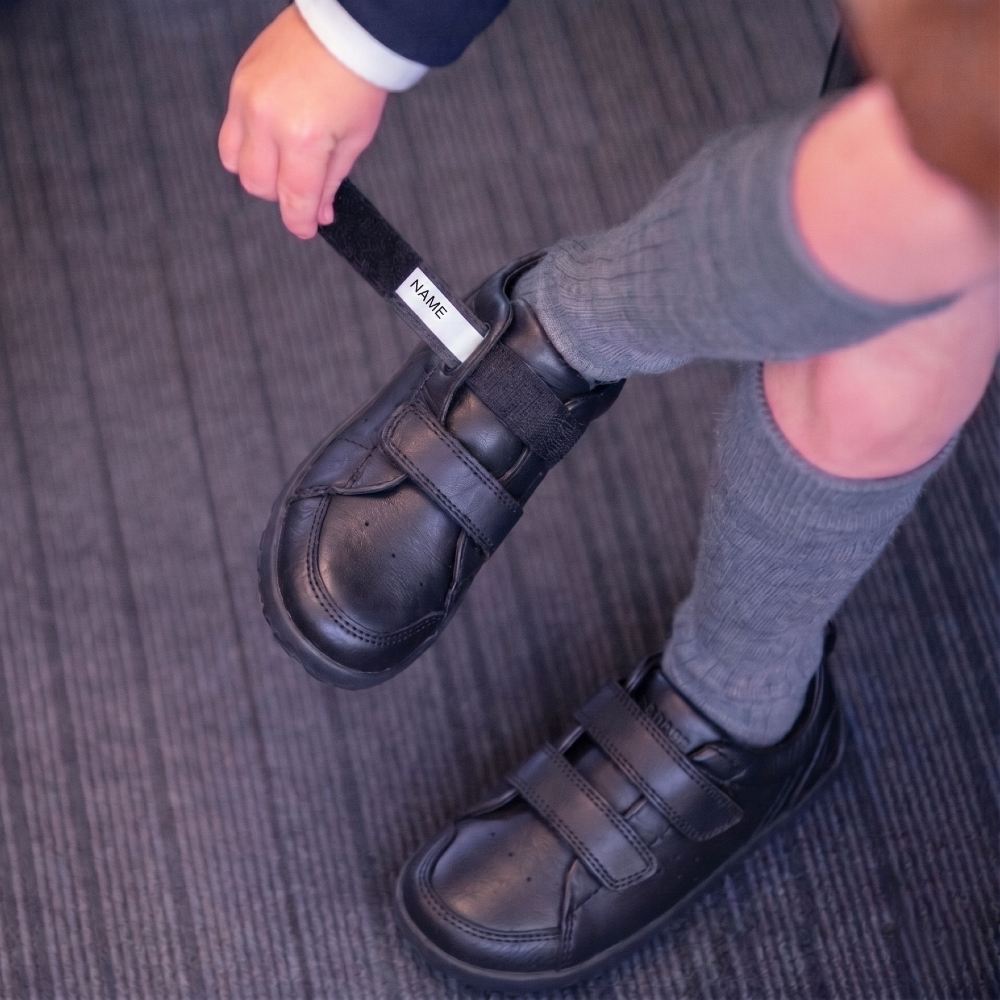 A school child showing the strap of their Bobux shoe with a name label on it 