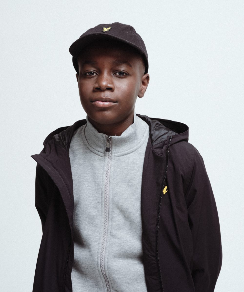 A boy wearing a cap, sweatshirt and sports jacket by Lyle & Scott Kidswear