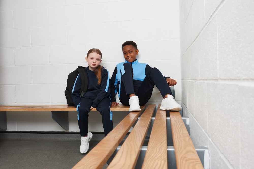 Two students in a changing room wearing tracksuits by Finden and Hales