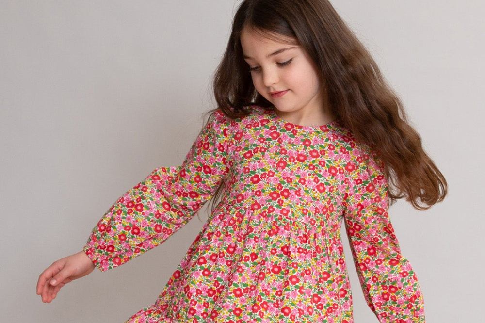 A girl in a floral dress from Kite Clothing's matching family Christmas collection