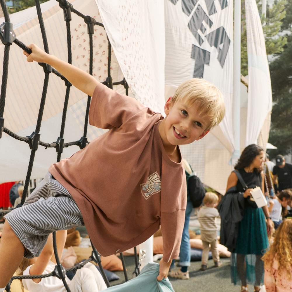A boy hanging off climbing ropes at the Wheat 25th anniversary event in Copenhagen