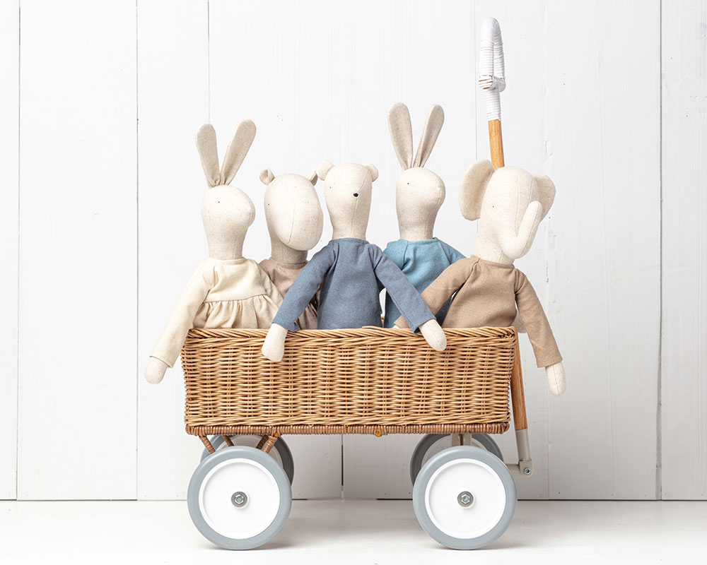 Five Pickles plush characters stood in a wooden wicker trolley