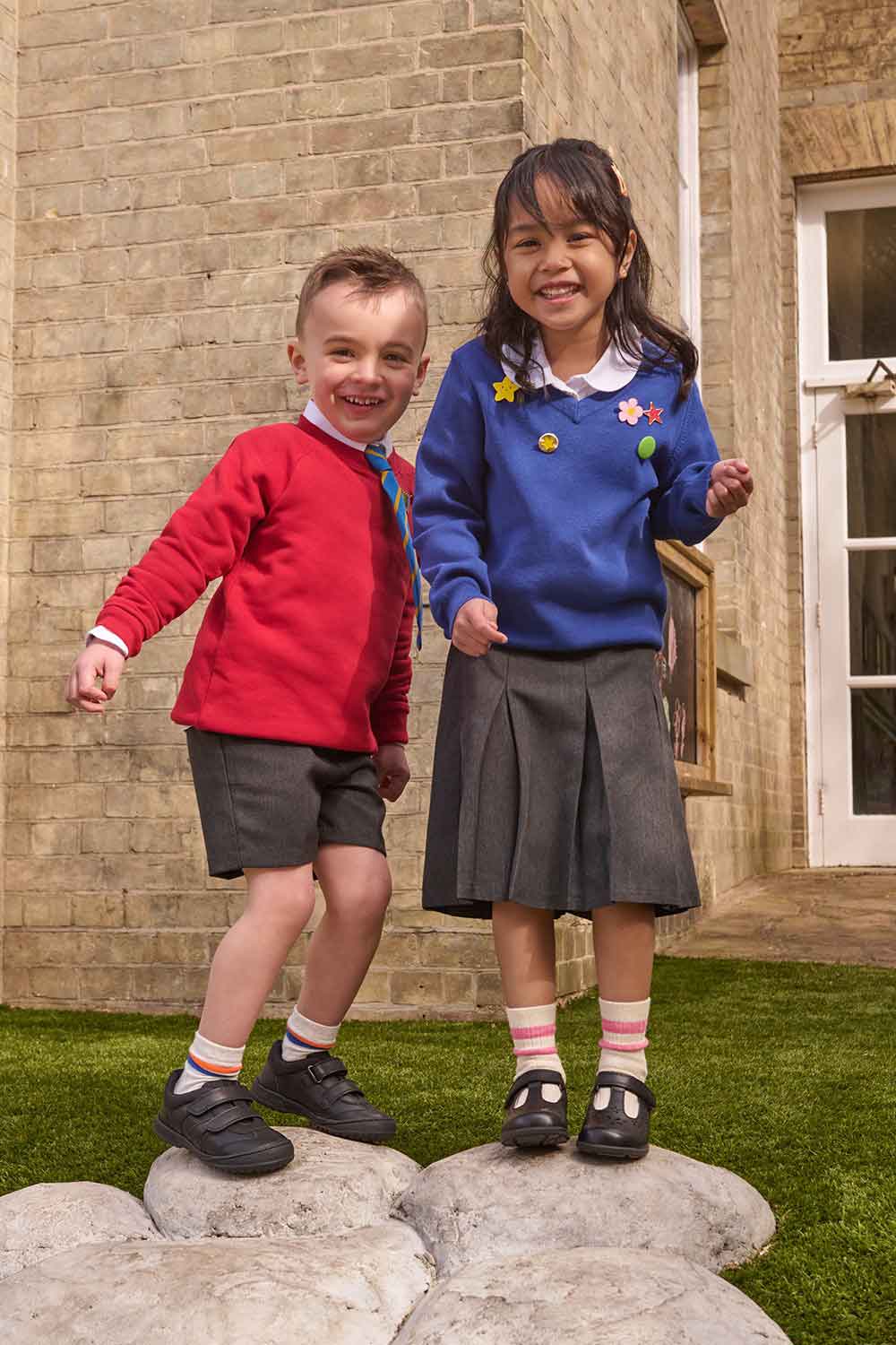 A boy and girl wearing school uniforms stood together